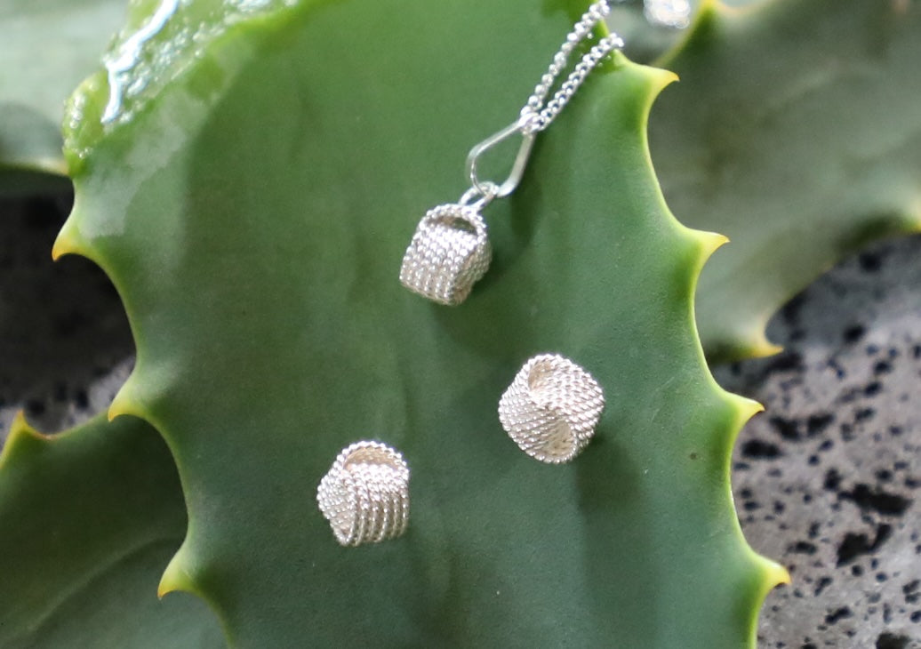 Juego de aretes y dije nudos plata .925
